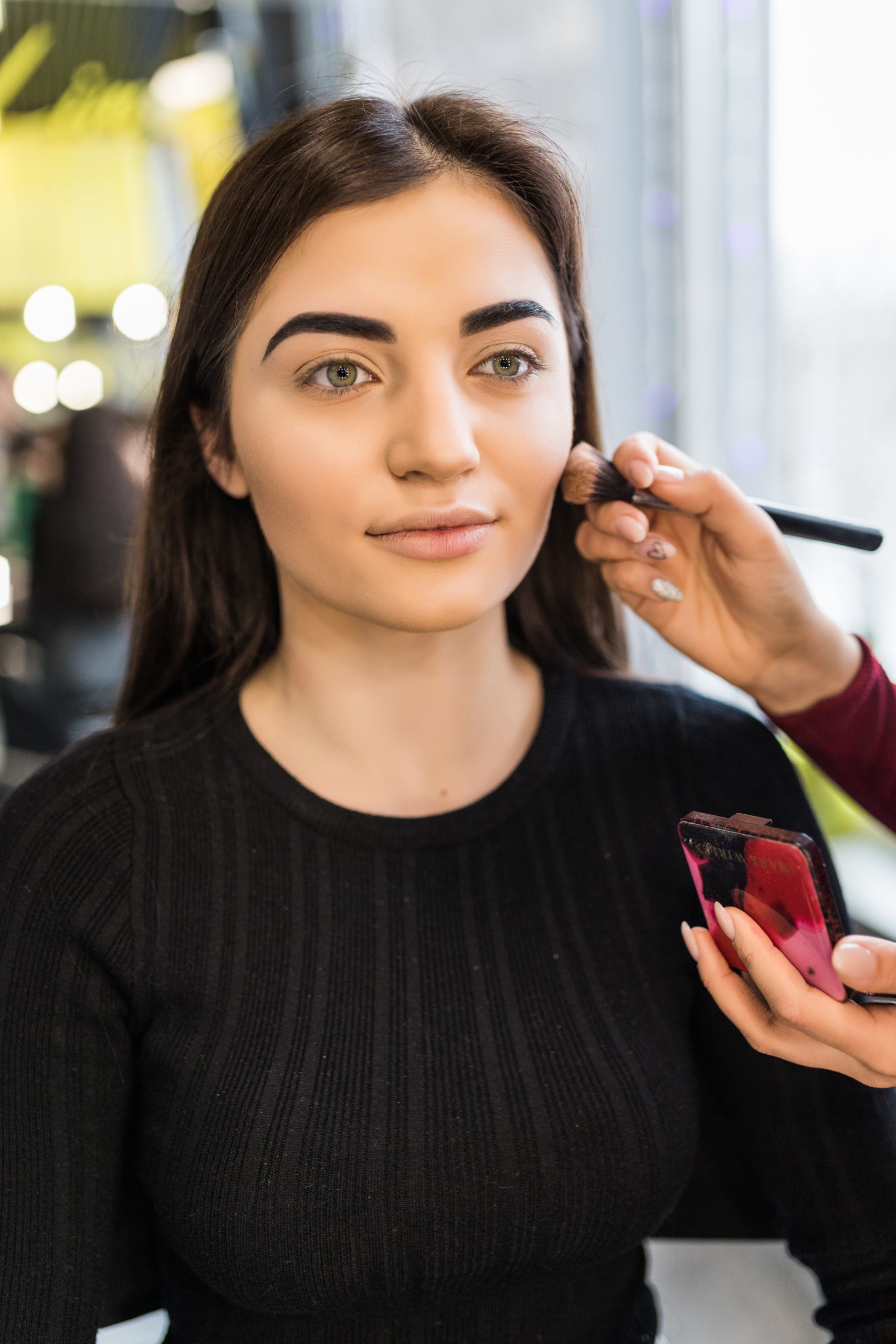 Young model in sweater have make-up procedure